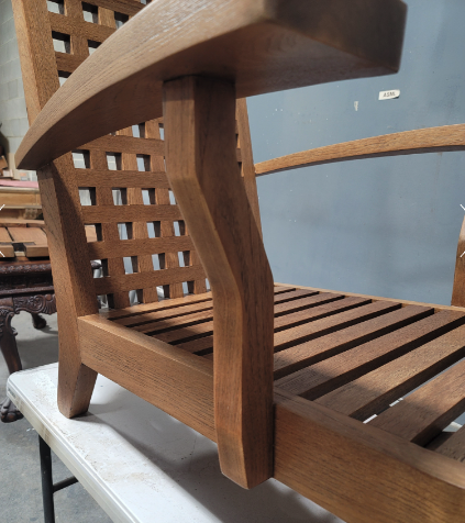 Detail of a refinished teak outdoor chair's joinery and armrest after waterborne finishing