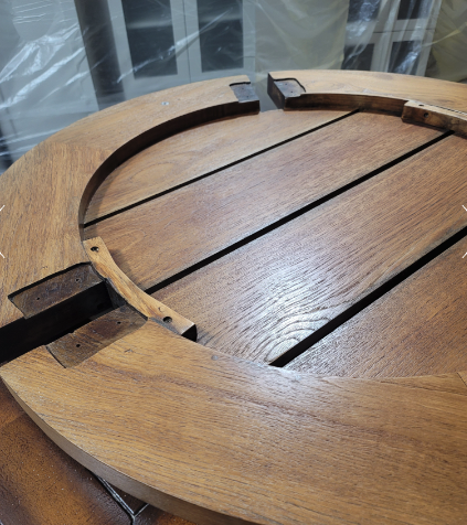 Close-up of a refinished teak outdoor table, showing the restored golden-brown wood grain