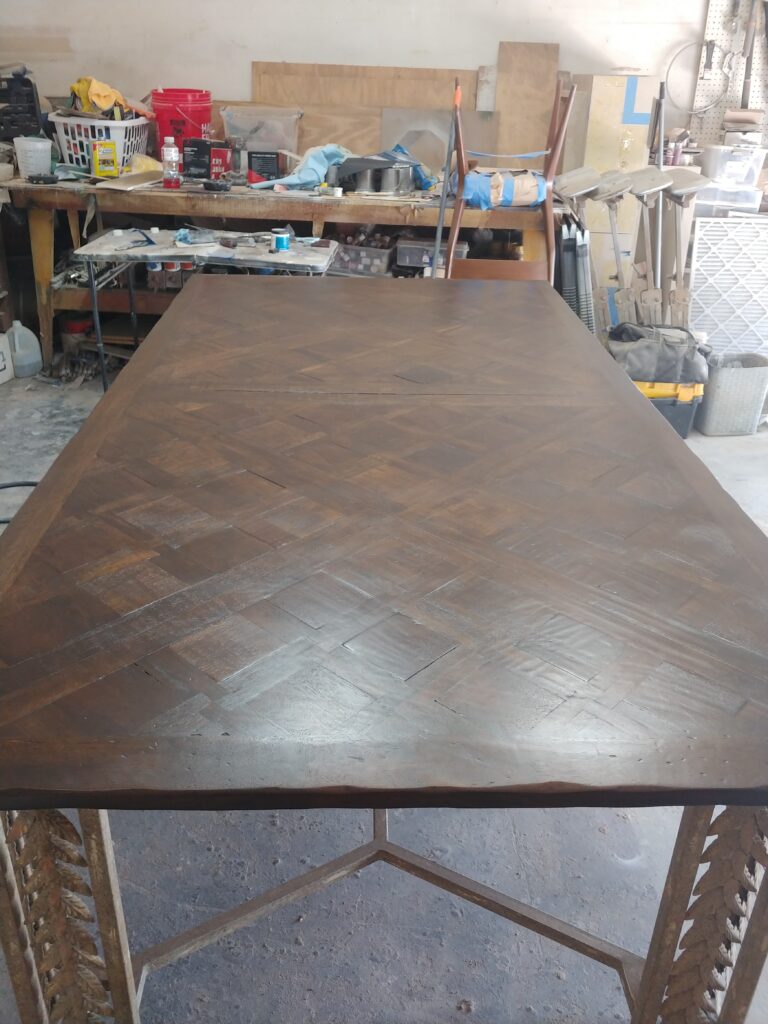 Finished mahogany parquet table top with rich, glossy stained diamond pattern after refinishing