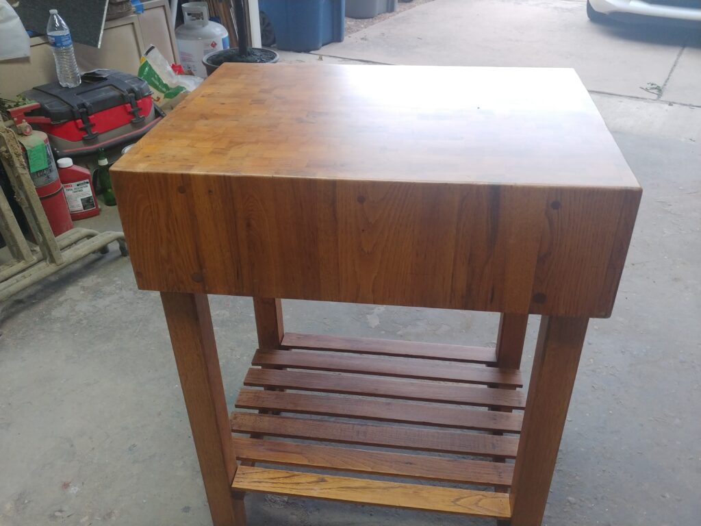 Side view of a restored oak butcher block cart showing the thick end-grain top and slatted lower shelf