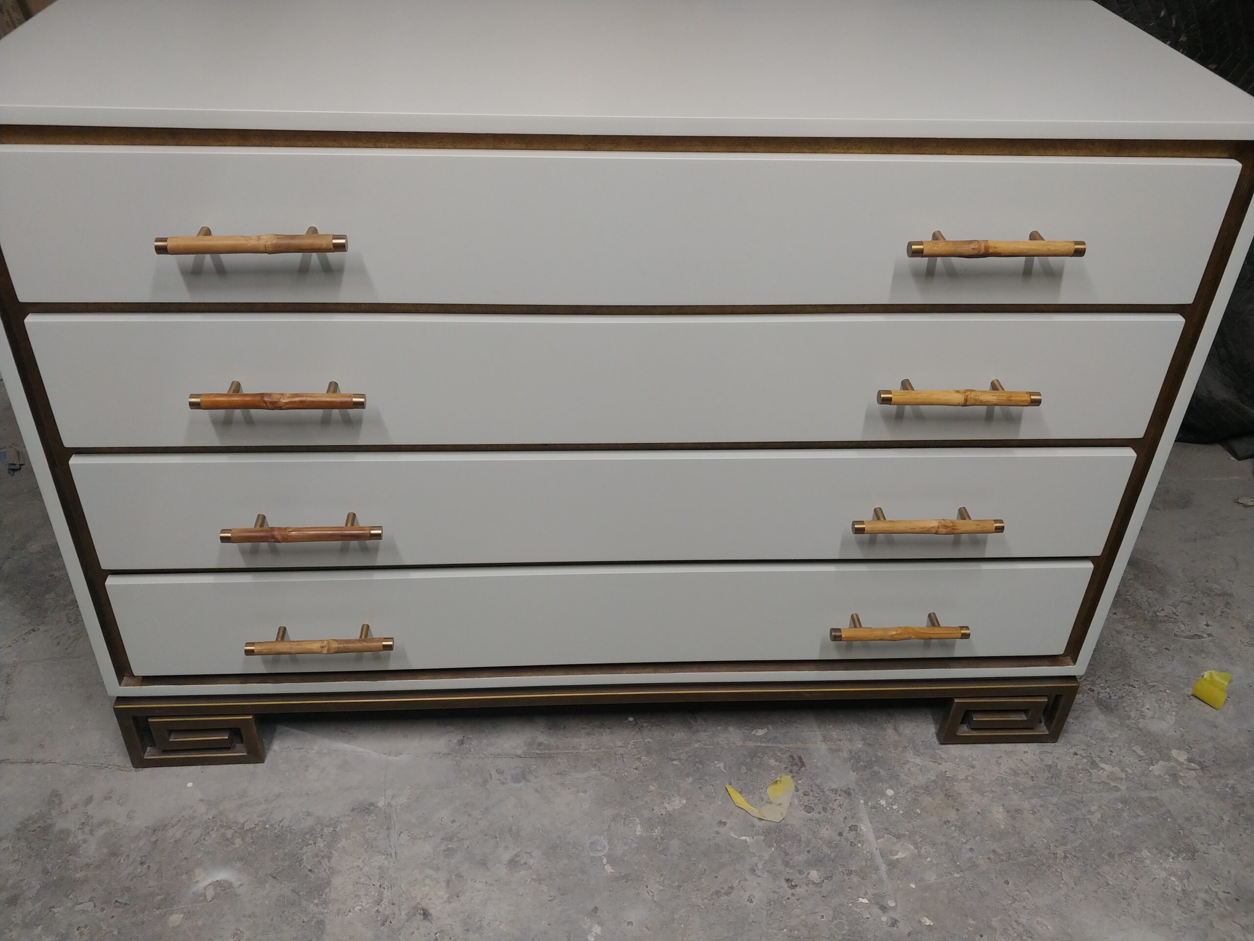 Gold leaf-trimmed dresser in Comfort Grey lacquer after refinishing