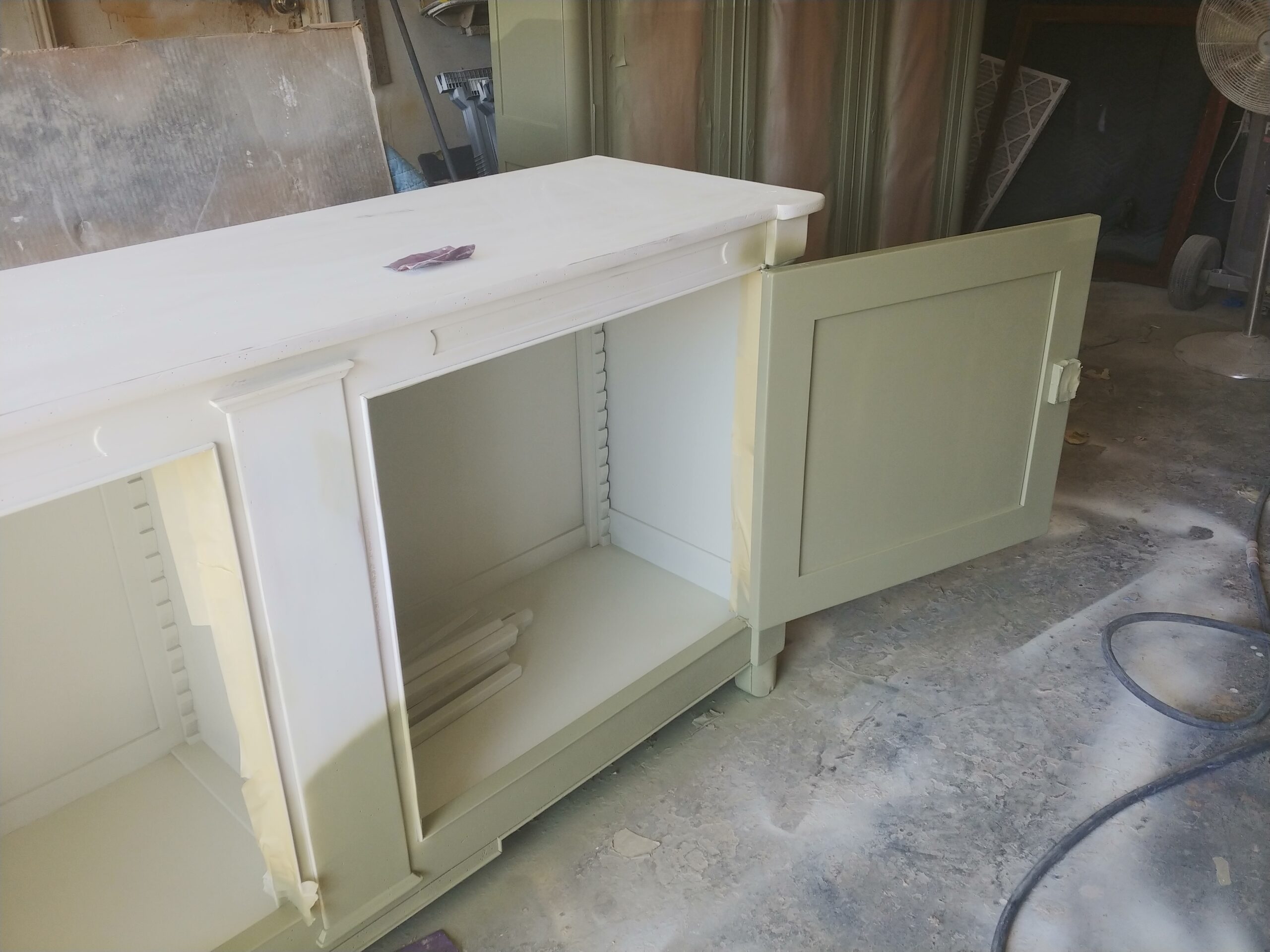 French buffet during lacquer refinishing, door open showing the lighter interior and sawtooth shelf supports